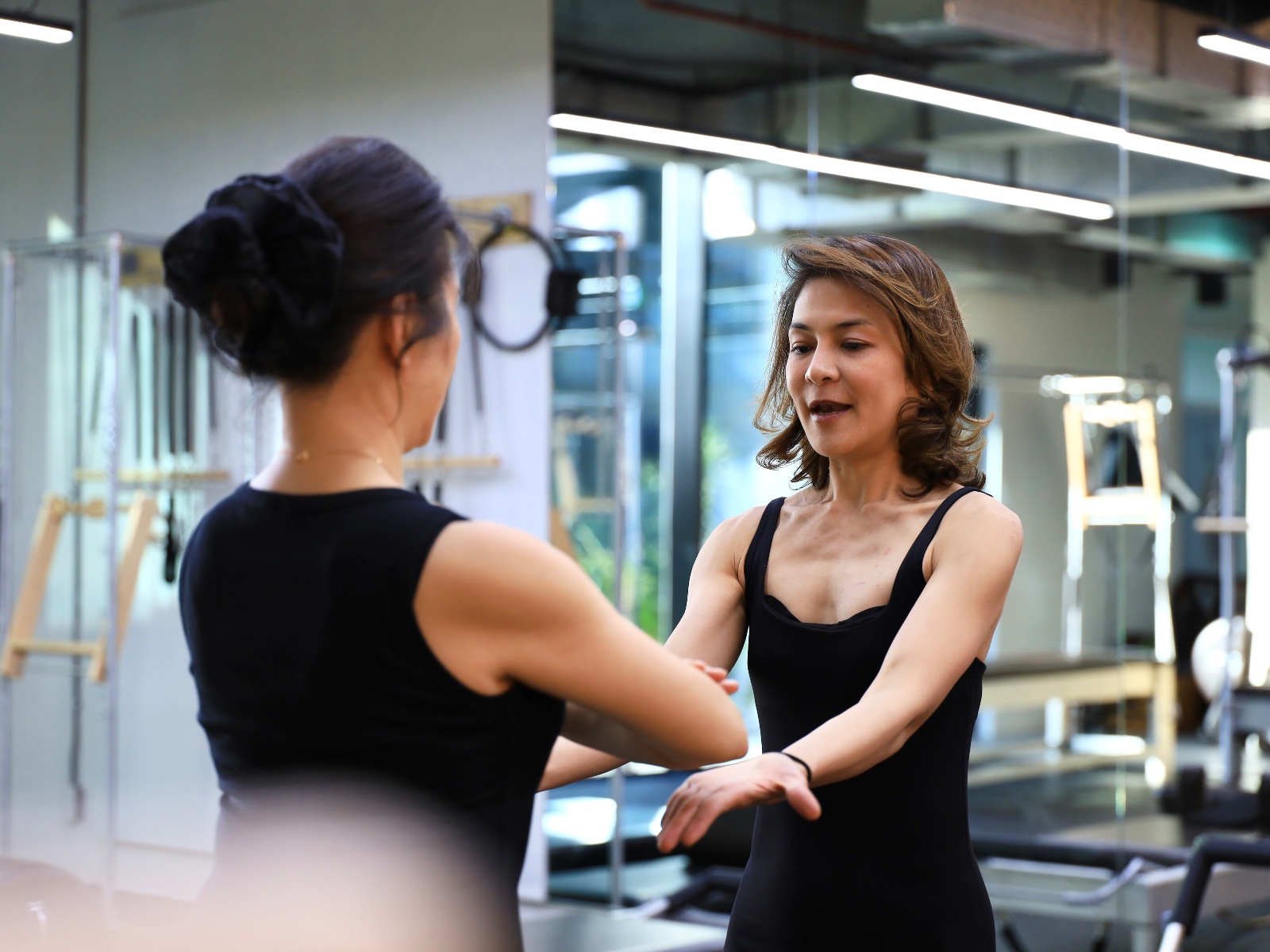Kru Kaew with hands-on adjustment during a movement