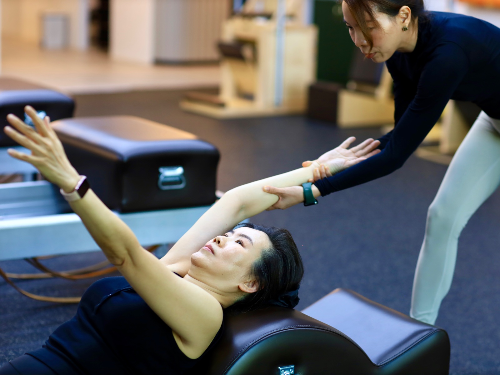 Kru Ple guiding a student on the apparatus